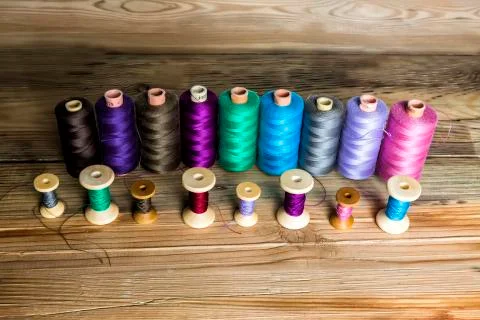 Spools of thread on wooden background. Old sewing accessories. colored thread Photos
