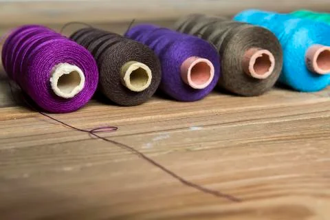 Spools of thread on wooden background. Old sewing accessories. colored thread Stock Photos