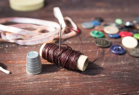 Spools of threads and buttons on old wooden table Stock-Fotos