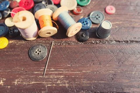 Spools of threads and buttons on old wooden table Stock-Fotos