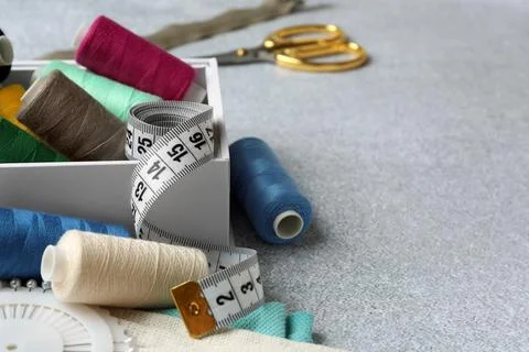 Spools of threads and sewing tools on light textured table, space for text Stock Photos