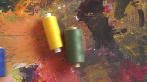 Spools of threads are rolling on painted background 스톡 동영상 222802130