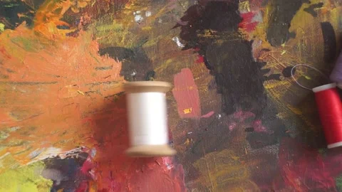 Spools of threads are rolling on painted background Stock Footage 222802189