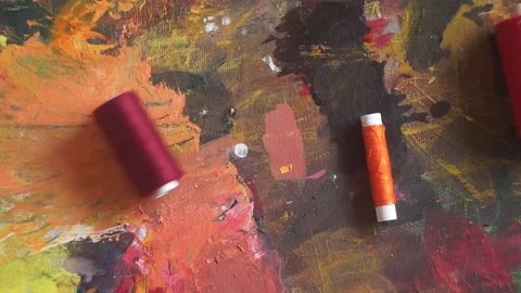 Spools of threads are rolling on painted background 스톡 동영상 222802233