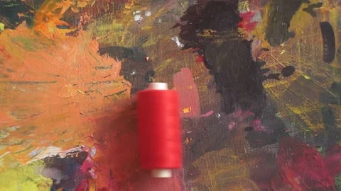 Spools of threads are rolling on painted background Stock Footage 222802270