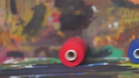Spools of threads are rolling on painted background Stock Footage 222802483