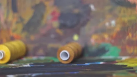 Spools of threads are rolling on painted background 스톡 동영상 222802484