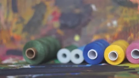 Spools of threads are rolling on painted background Stock Footage 222802494