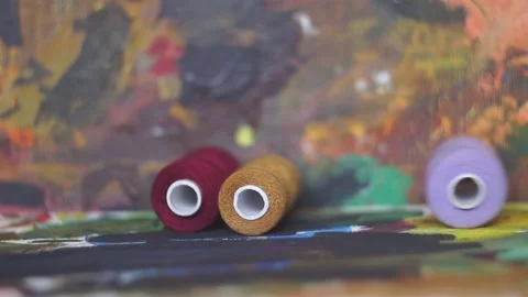 Spools of threads are rolling on painted background 스톡 동영상 222802546