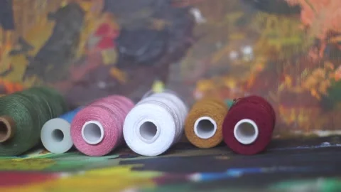 Spools of threads are rolling on painted background Stock Footage 222802635