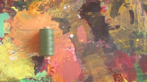 Spools of threads are rolling on painted background Stock Footage 222802637