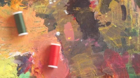 Spools of threads are rolling on painted background 스톡 동영상 222802670