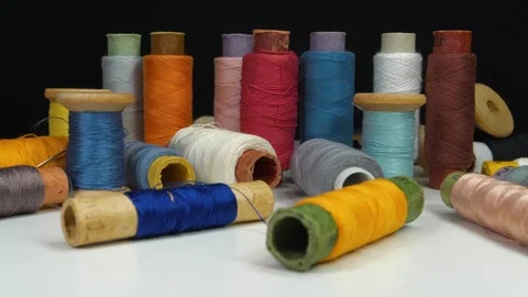 Spools with varicolored threads rotates on black background, 4K 60fps video Stock Footage 311453615