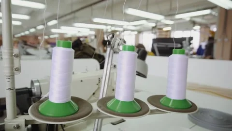 Spools with white threads on rack near sewing machine tool Stock Footage 236907515
