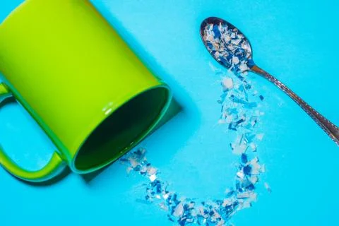 Spoon and cup with microplastics Stockfoto's