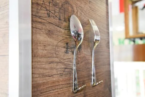 Spoon and fork as hooks for clothes. The decor of the restaurant, coffee shop Stock Photos