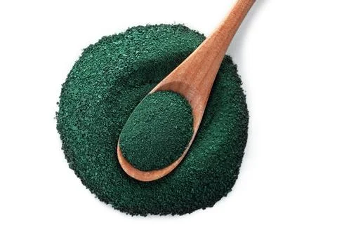 Spoon and heap of spirulina algae powder on white background, top view Foto stock