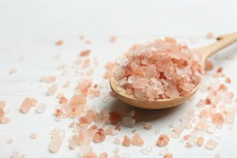 Spoon and pink himalayan salt on white wooden table, closeup Stock Photos