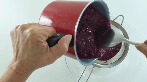 With spoon and sieve, preparing jam and sifting jaboticaba or jaboticaba. 库存影片 128821196