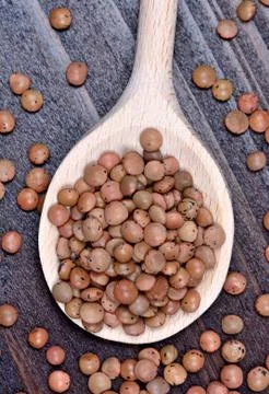 Spoon with brown lentils on table Stock Photos