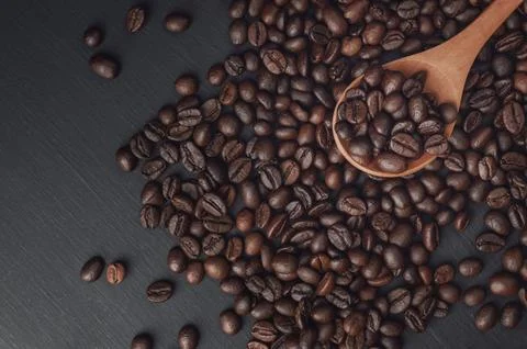 Spoon with coffee on a black background.  spoon with coffee beans. coffee b.. Stock Photos