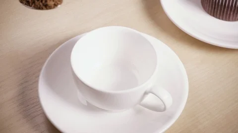 A spoon with coffee in a woman's hand is pouring into a cup slow motion Stock Footage 88822012