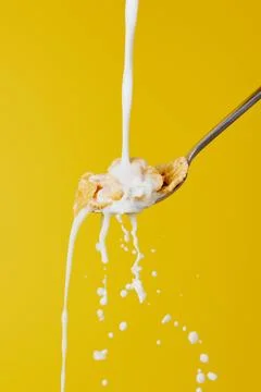 Spoon cornflakes milk stream splashes Stock Photos