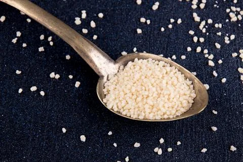 Spoon of couscous on dark background Stock Photos