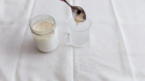Spoon Dips into Sour Cream: Smooth Transfer to Clear Glass Vessel Stock Footage 312673333
