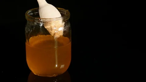 Spoon dripping honey in a jar Stock Footage 84968613