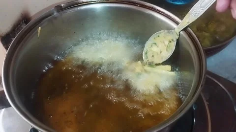 Spoon dropping  into a  hot oil for preparing pakoras fritters fried Stock Footage 337161911