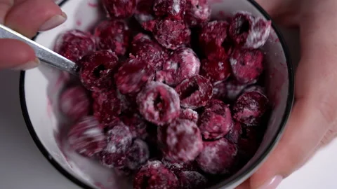 A spoon is filled with a mixture of fruit. a person holding a spoon in a bowl of Stock-Footage 231756758