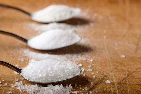 Spoon filled with salt Stock Photos