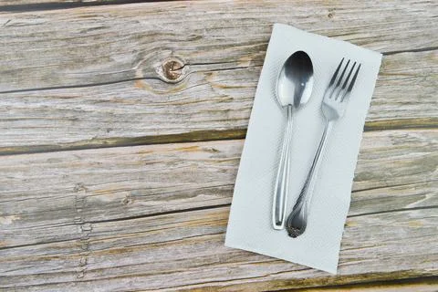 Spoon, fork and tissue over wooden background with copy space. Foto stock