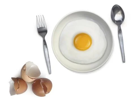 Spoon fork fried egg on plate on a white background Stock Photos