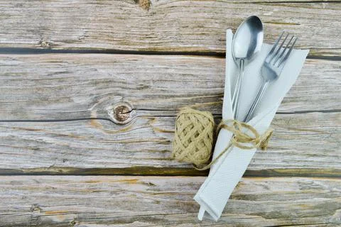 Spoon, fork, tissue and hemp rope over wooden background Foto stock