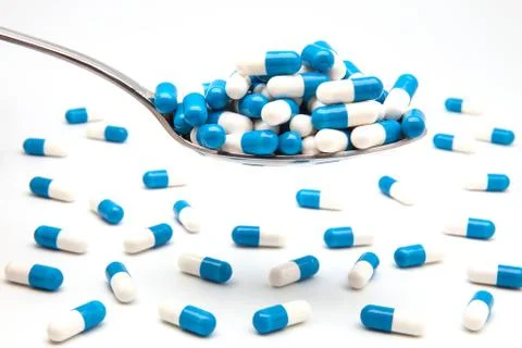 Spoon full of capsules Stock Photos