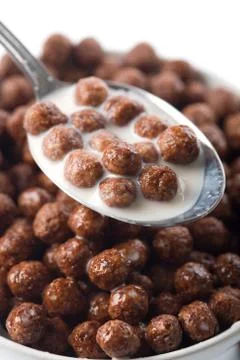 Spoon full of chocolate balls and milk isolated Stock Photos