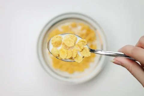 Spoon full of cornflakes in hand close-up breakfast concept Stock Photos