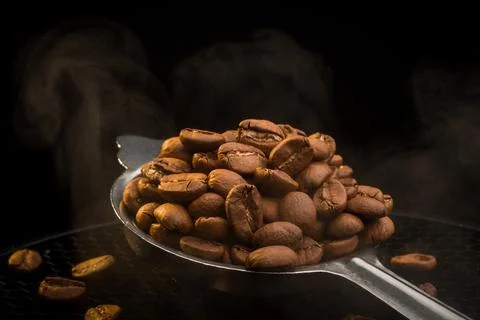 Spoon Full of Roasted Coffee Beans with Steam Stock Photos