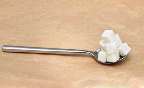Spoon full with white sugar cubes pile Stock Photos