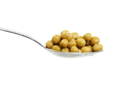Spoon with green peas Stock Photos