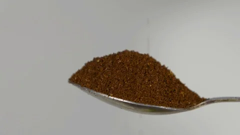 Spoon with ground coffee flips over and spills coffee on a white background Stock Footage 122727715