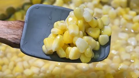 A Spoon Holding Corn Kernels Stock Photos
