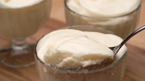 The spoon is immersed in white air mousse in a glass dish 库存影片 240752661
