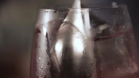 A spoon is inserted into the glass with the ingredients and begins to mix them 스톡 동영상 136217010