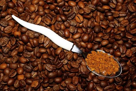 A spoon with instant coffee on a background of beans Foto stock