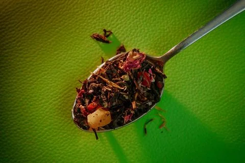Spoon with leaf tea on a green background Stock Photos