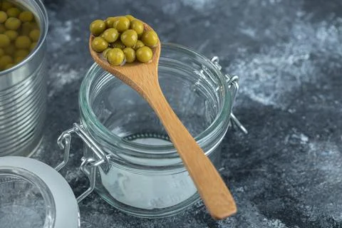 Spoon olive over empty jar on grey background Stock Photos