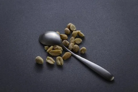Spoon with peanuts on dark surface clean eating still life Stock-Fotos